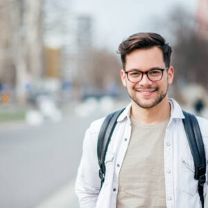 Portrait of a smiling student at the city street.